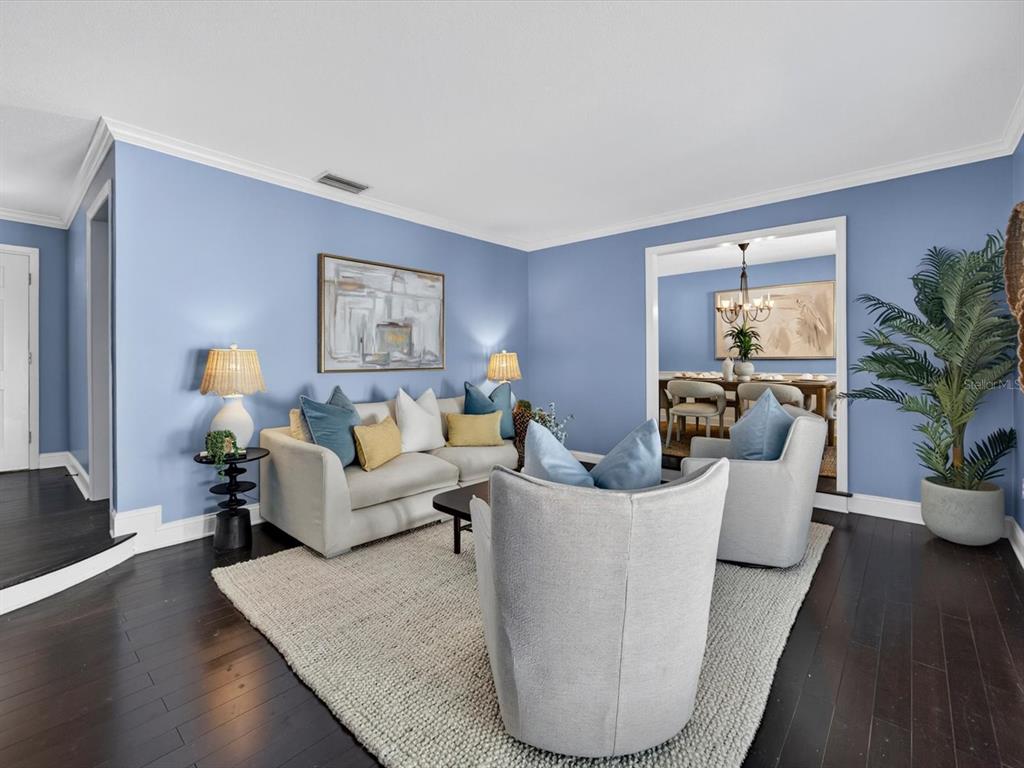 A living room with blue walls, light-colored furniture, and dark hardwood floors — 333 CORNWALL ROAD, WINTER PARK, FL