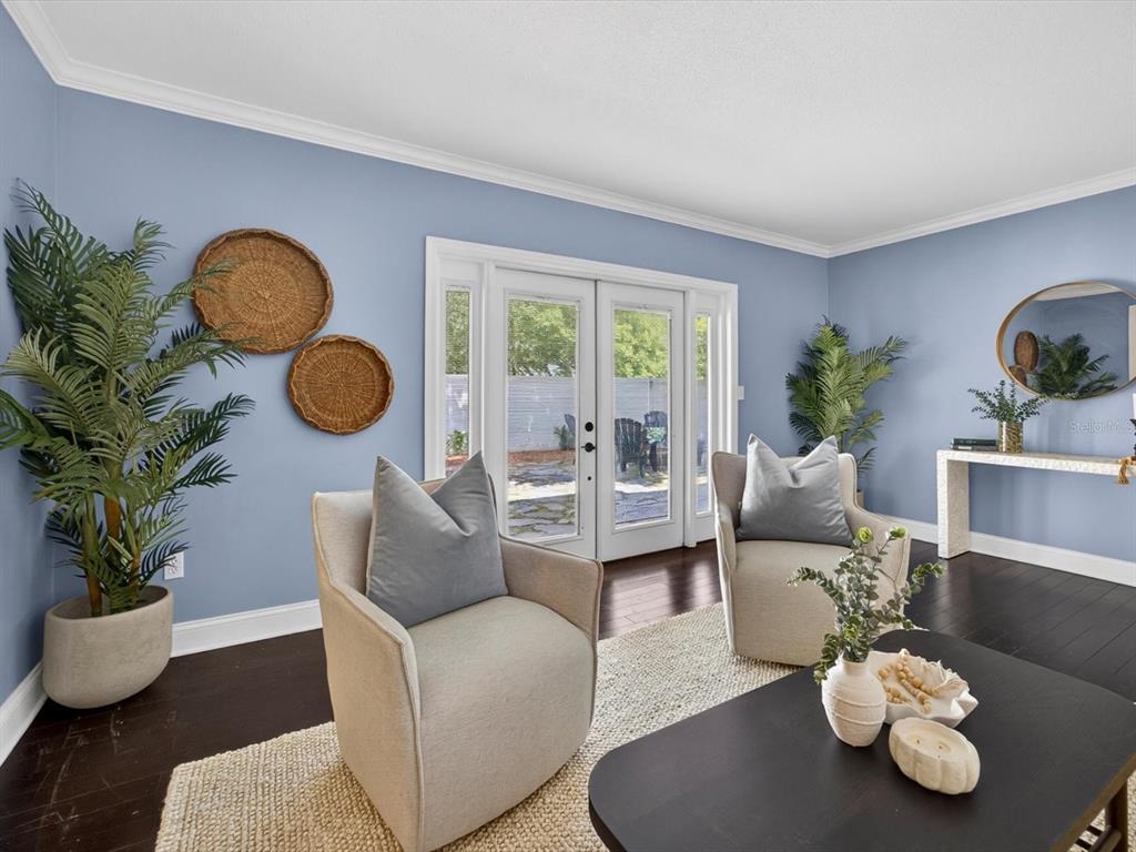 A living room features light blue walls, two beige armchairs, and French doors to a patio — 333 CORNWALL ROAD, WINTER PARK, FL