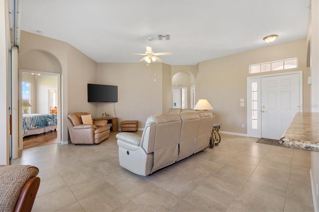 A living room features light tile floors, a neutral color palette, and a white sofa — 17584 SE 119TH CIRCLE, SUMMERFIELD, FL