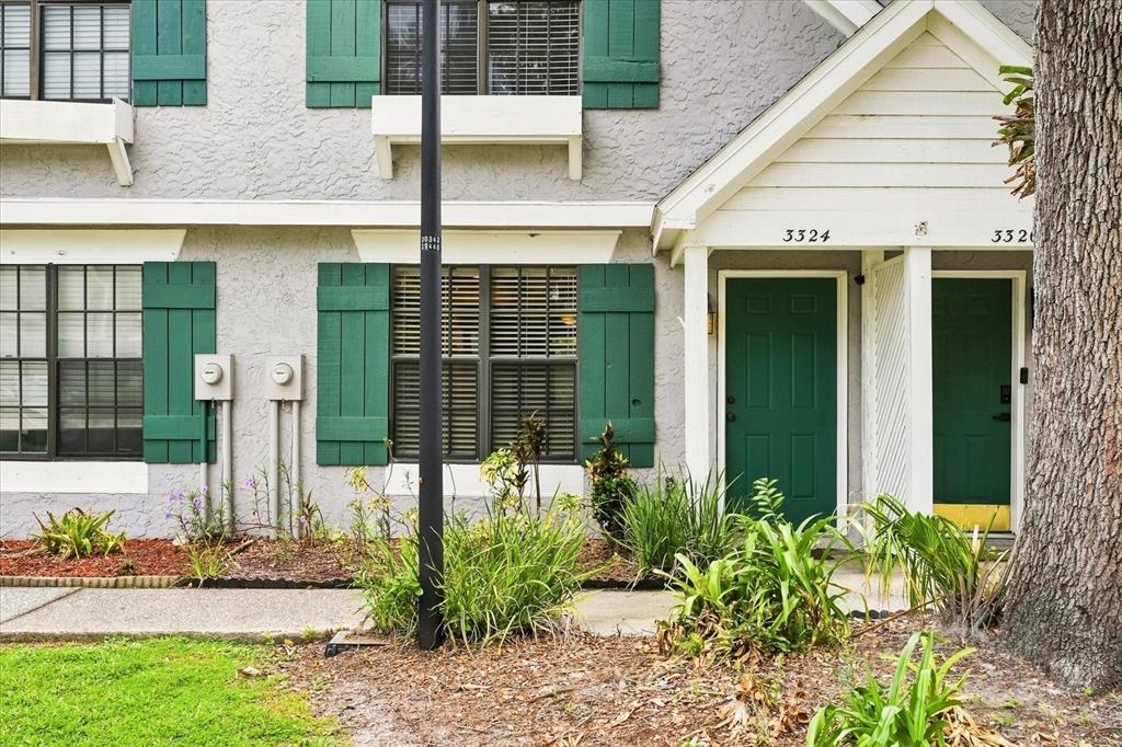 Exterior view of a two-story townhouse with gray stucco, green shutters, and green front doors — 3324 LAUREL VIEW DRIVE, BRANDON, FL