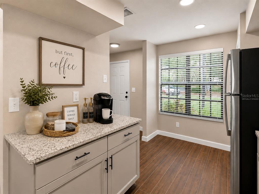 A kitchen area features light gray cabinets, granite countertops, a coffee station, and wood-look flooring — 3324 LAUREL VIEW DRIVE, BRANDON, FL