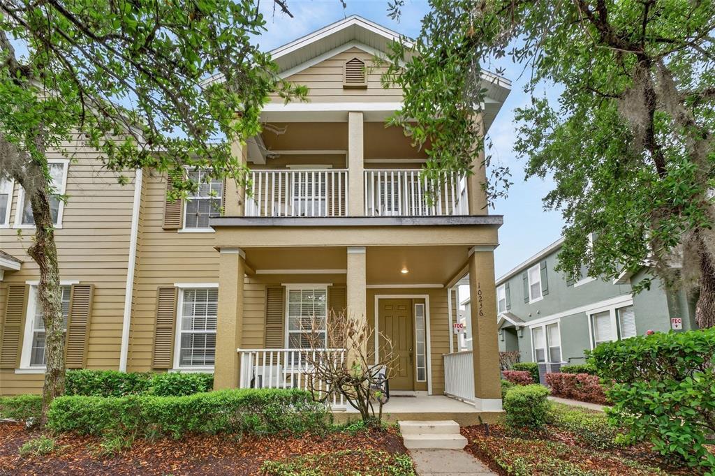 A two-story house with tan siding, a front porch, and a second-story balcony — 10236 LAKE DISTRICT LANE UNIT 35C, ORLANDO, FL