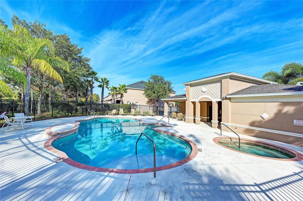 A swimming pool and hot tub are located on a patio next to a building — 1510 GRANTHAM DRIVE, SARASOTA, FL