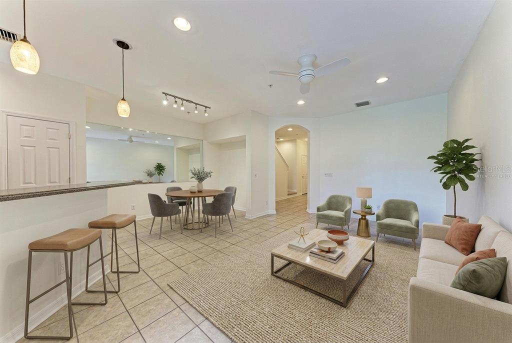 An open-concept living and dining area features tile flooring, neutral walls, and modern furniture — 1510 GRANTHAM DRIVE, SARASOTA, FL