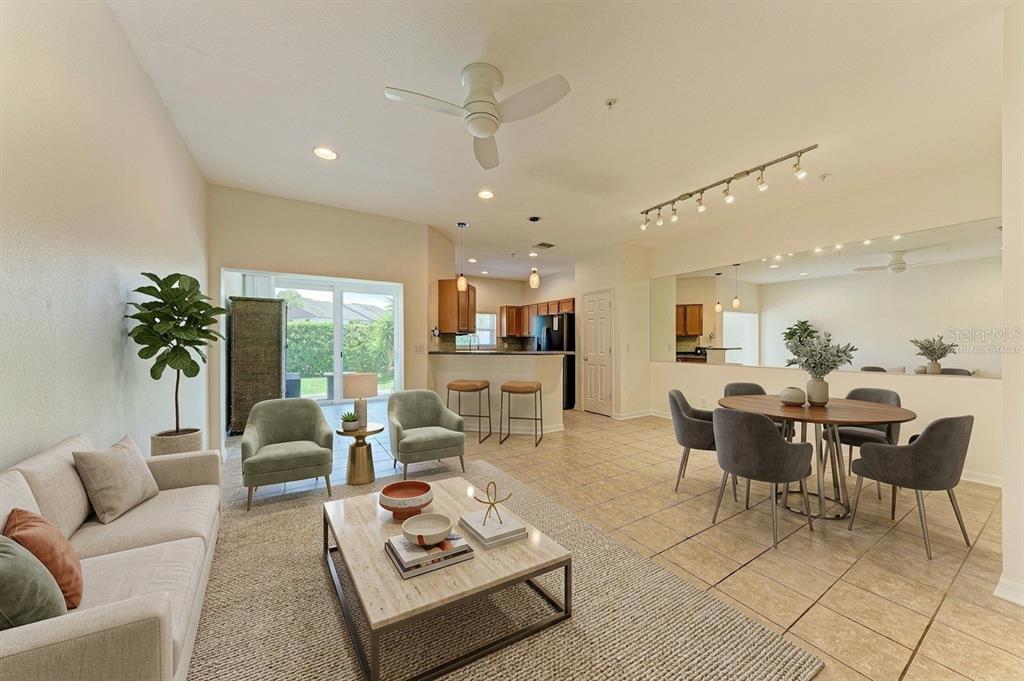 An open-concept living and dining area features tile floors, a kitchen island, and sliding doors — 1510 GRANTHAM DRIVE, SARASOTA, FL