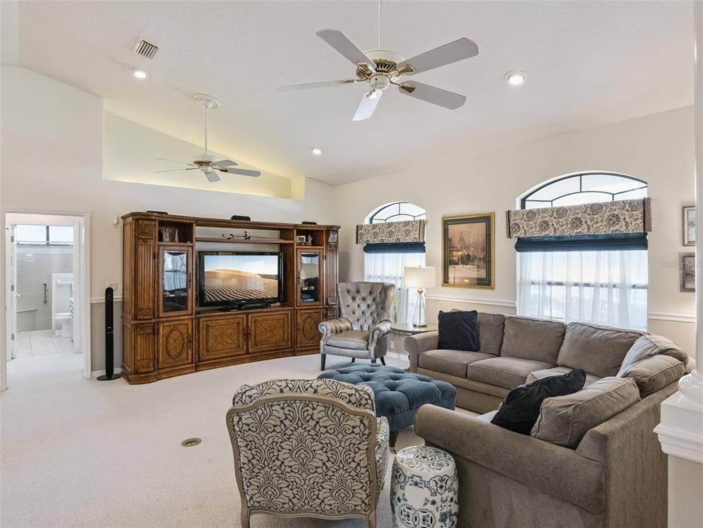 A living room features a large wooden entertainment center, a sectional sofa, and two armchairs — 21824 TARTAN STREET, LEESBURG, FL