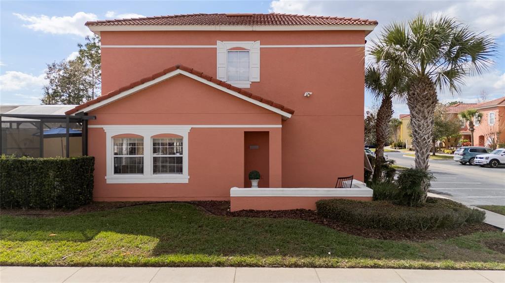 A two-story peach-colored house with a tiled roof, a small front patio, and palm trees — 4756 ORMOND BEACH WAY, KISSIMMEE, FL