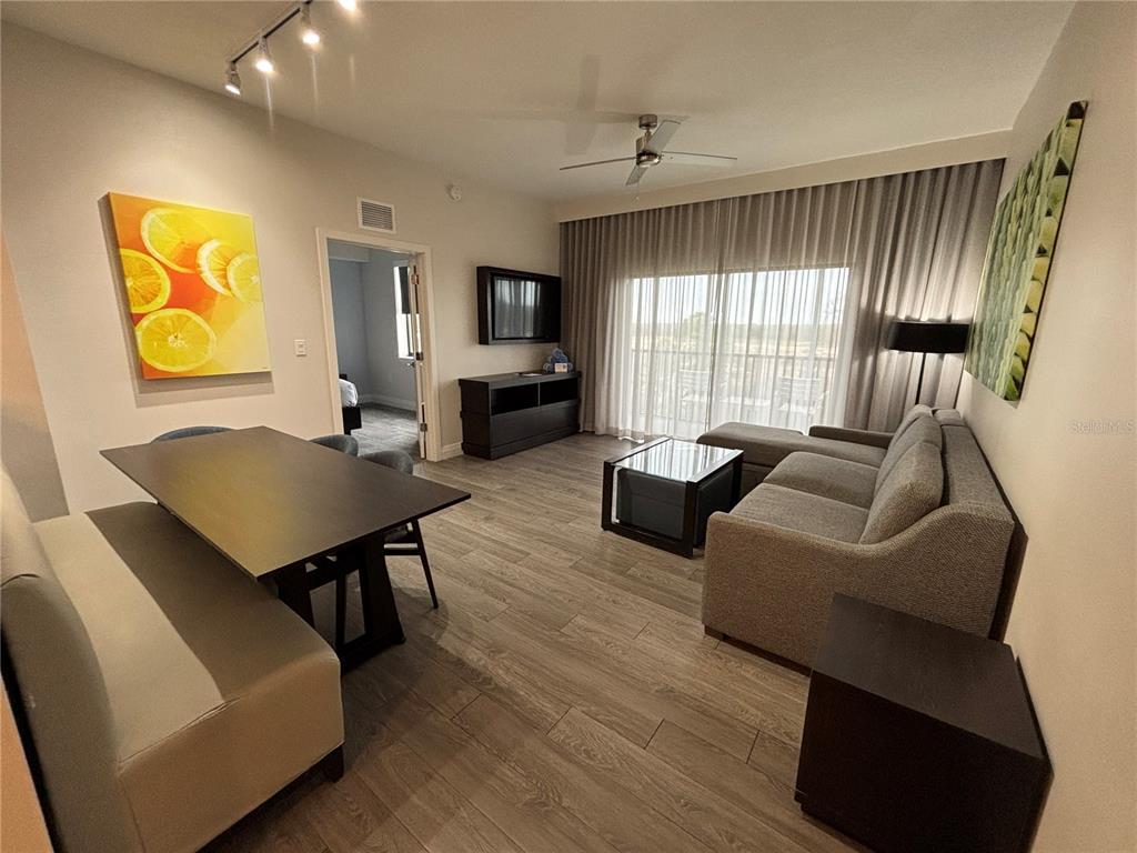 A living and dining area features wood-look flooring, a sectional sofa, and a dining table — 14501 GROVE RESORT AVENUE UNIT 2532, WINTER GARDEN, FL