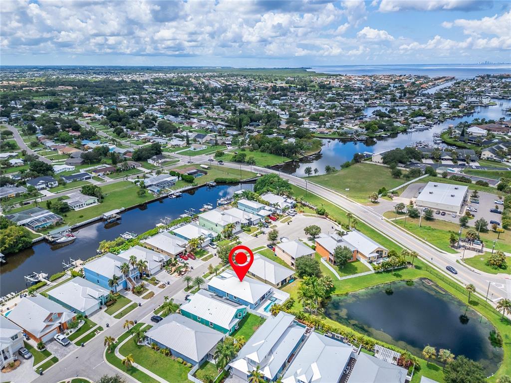 An aerial view shows a residential neighborhood with a red pin marking a specific house — 567 BIMINI BAY BOULEVARD, APOLLO BEACH, FL
