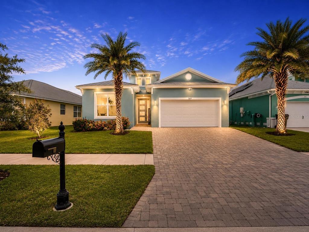 A light blue single-story house with a paved driveway, two palm trees, and a garage — 567 BIMINI BAY BOULEVARD, APOLLO BEACH, FL