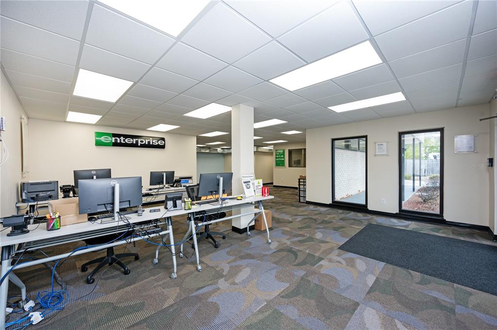 An office interior features an Enterprise sign, multiple computer workstations, and patterned carpet flooring — 313 18TH AVE S STREET, ST PETERSBURG, FL
