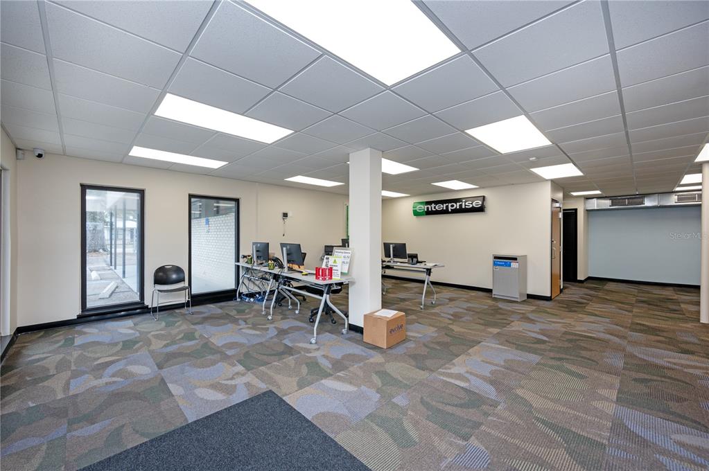 An office interior features carpeted flooring, drop ceilings, workstations, and an Enterprise sign on the wall — 313 18TH AVE S STREET, ST PETERSBURG, FL