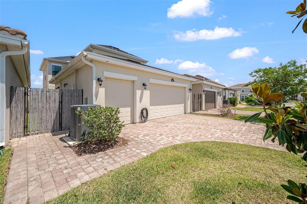 A beige house with a three-car garage and a paved driveway under a blue sky — 8048 GULLEN DRIVE, MELBOURNE, FL