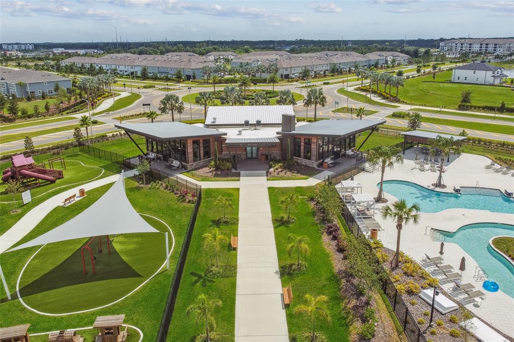 An aerial view of a community clubhouse with a swimming pool and a playground — 5663 MAYDALE AVENUE, WESLEY CHAPEL, FL
