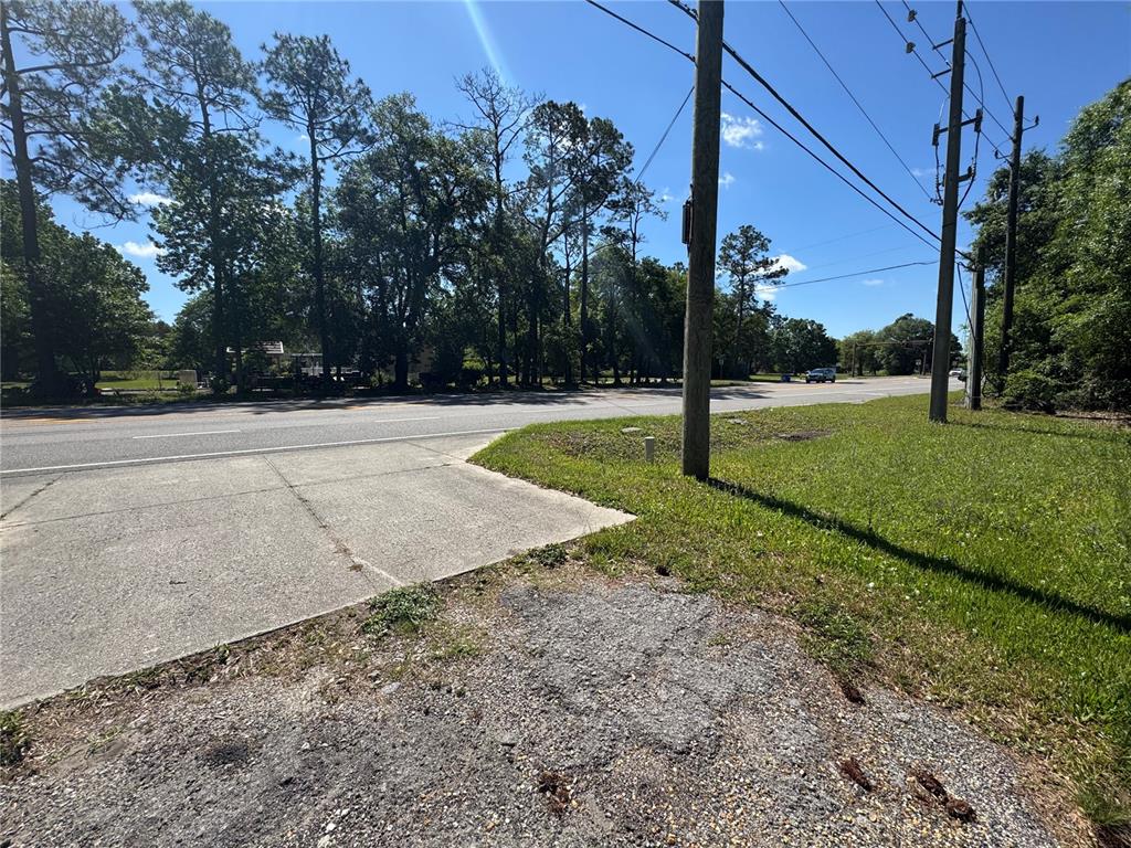 A paved driveway meets a road with utility poles and trees in the background — 2981 PACETTI ROAD, ST AUGUSTINE, FL