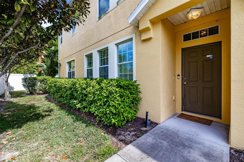 An open-concept living room features a sectional sofa, wood flooring, and a tiled entryway — 8726 MOONLIT MEADOWS LOOP, RIVERVIEW, FL