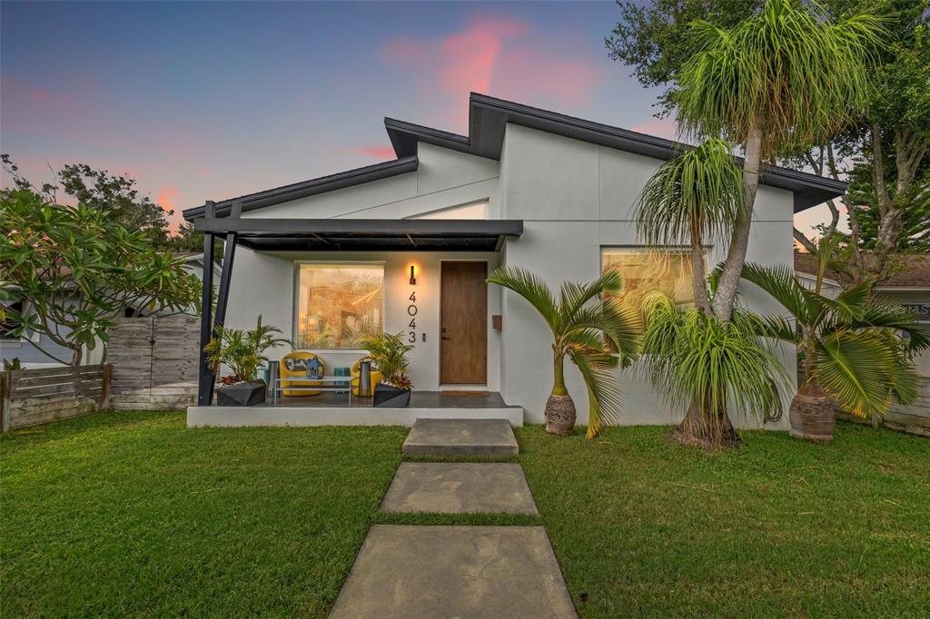 A modern single-story house with a flat roof, a covered porch, and a concrete walkway — 4043 7TH AVENUE N, ST PETERSBURG, FL