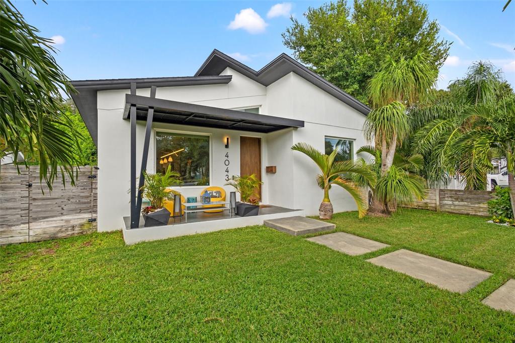 A modern white house with a black pergola, front porch, and a grassy yard — 4043 7TH AVENUE N, ST PETERSBURG, FL