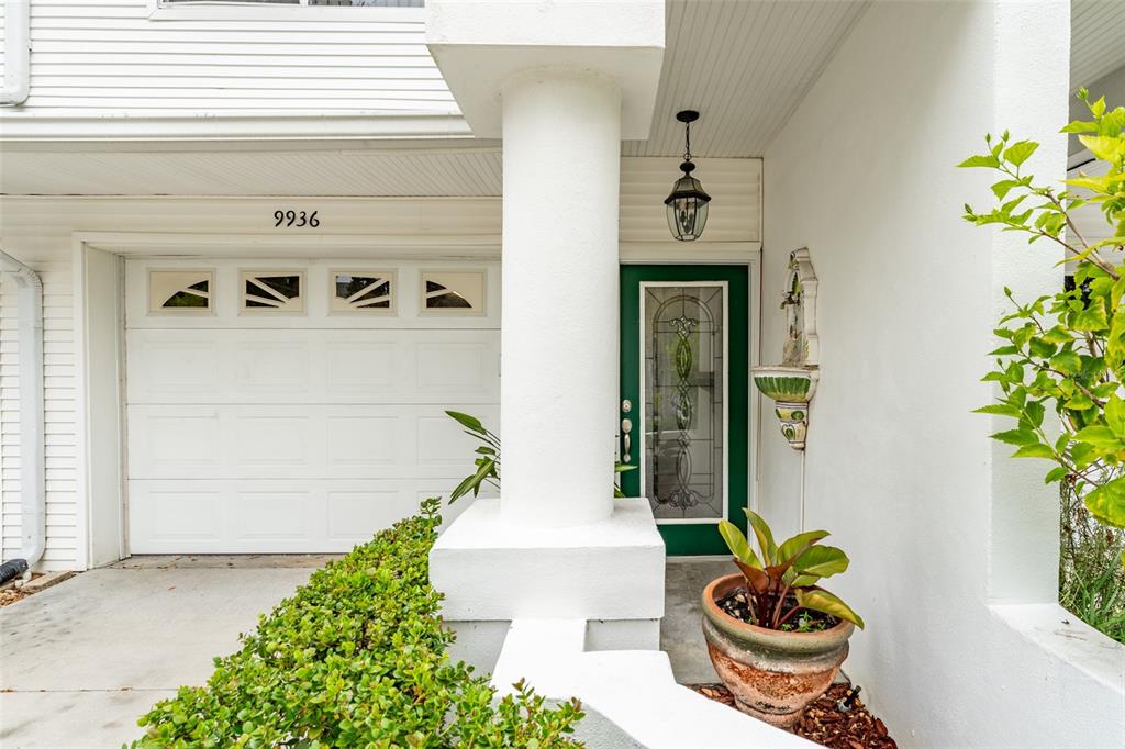 A white garage door and a green front door are visible under a covered entryway — 9936 INDIAN KEY TRAIL UNIT 22, SEMINOLE, FL