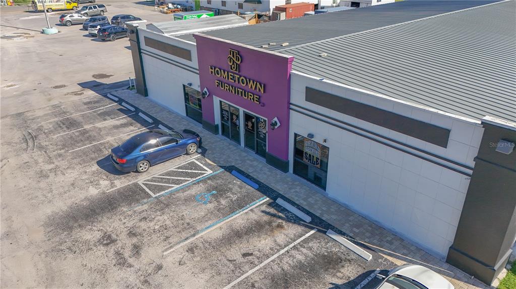 An aerial view shows the exterior of a commercial building labeled Hometown Furniture with parking — 14 W HICKORY STREET, ARCADIA, FL