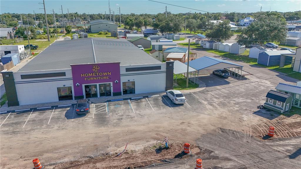 An aerial view shows a commercial furniture store building with a parking lot and storage sheds — 14 W HICKORY STREET, ARCADIA, FL
