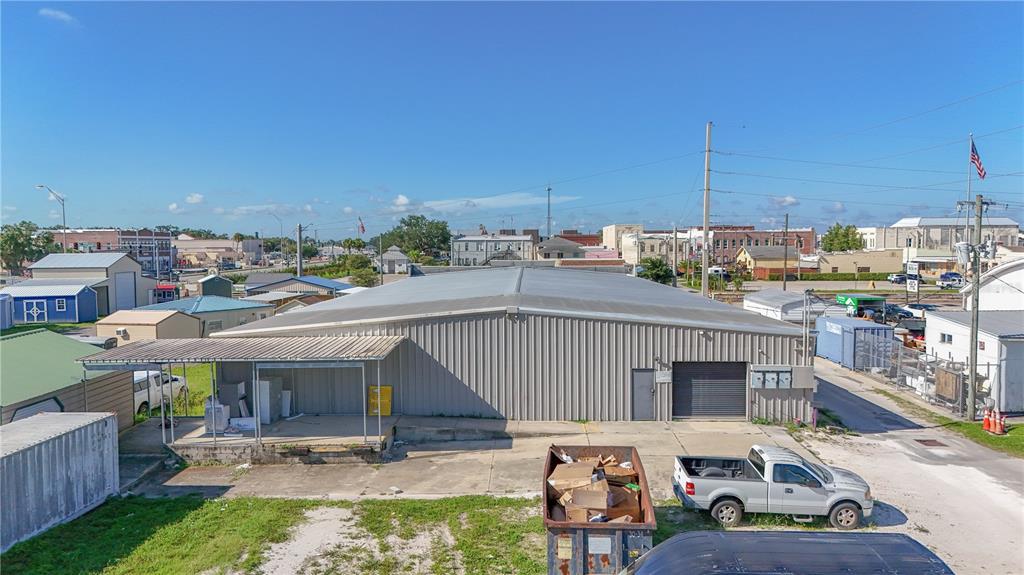 An exterior view of a metal warehouse building with a loading dock and a dumpster — 14 W HICKORY STREET, ARCADIA, FL