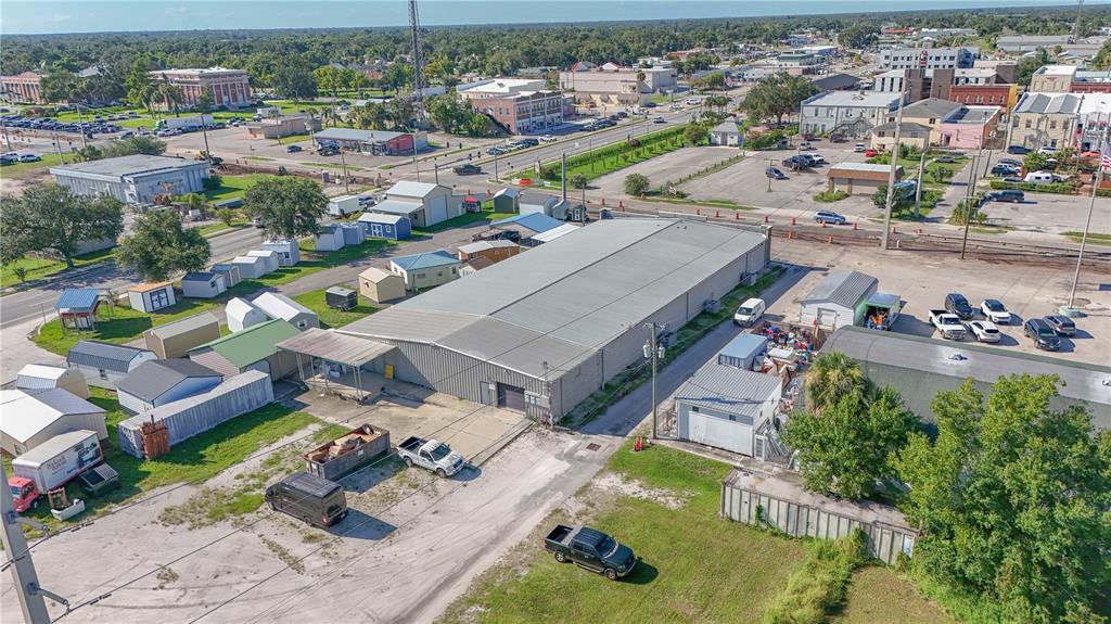 An aerial view shows a large industrial warehouse building surrounded by smaller sheds and parking lots — 14 W HICKORY STREET, ARCADIA, FL