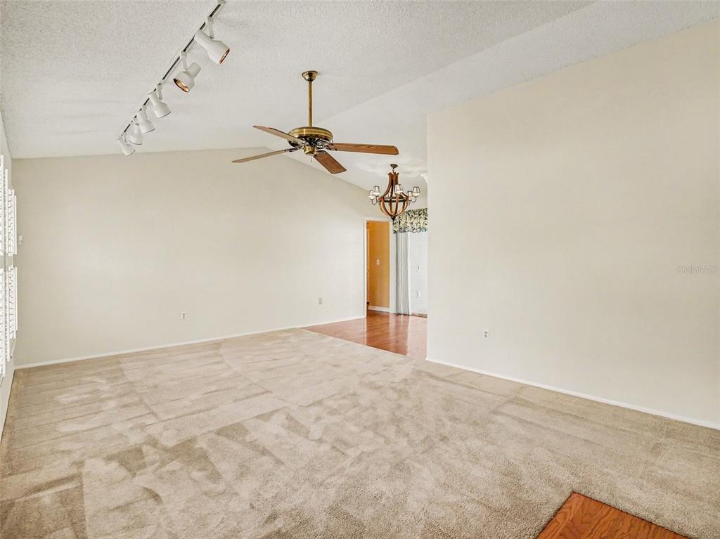 A dining area with wood flooring leads to a kitchen and a sliding glass door — 7207 IMMOKALEE COURT, ORLANDO, FL