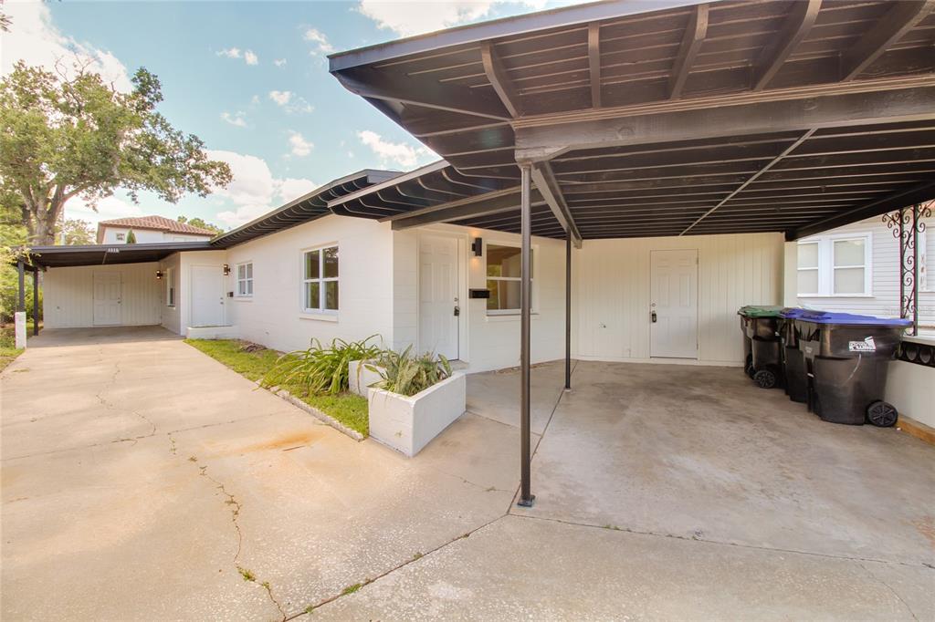 A white single-story house features a large attached carport and a concrete driveway — 1618 INDIANA AVENUE UNIT 1616, WINTER PARK, FL