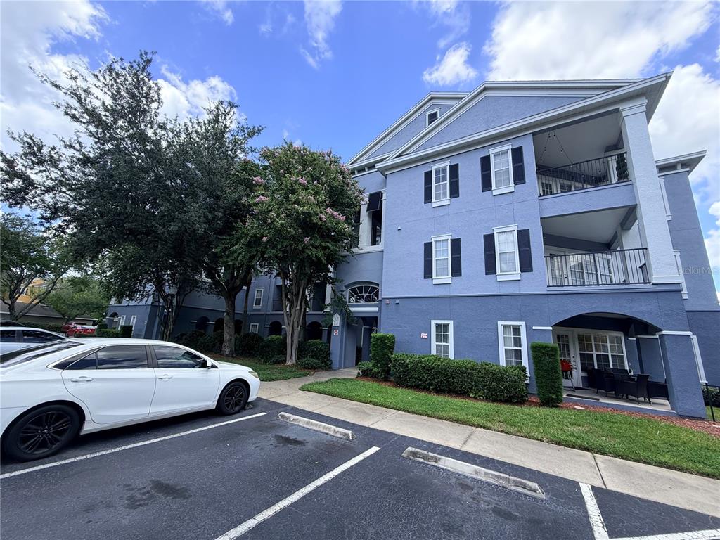 A three-story blue apartment building with balconies and a parking lot in the foreground — 3621 CONROY ROAD UNIT 732, ORLANDO, FL