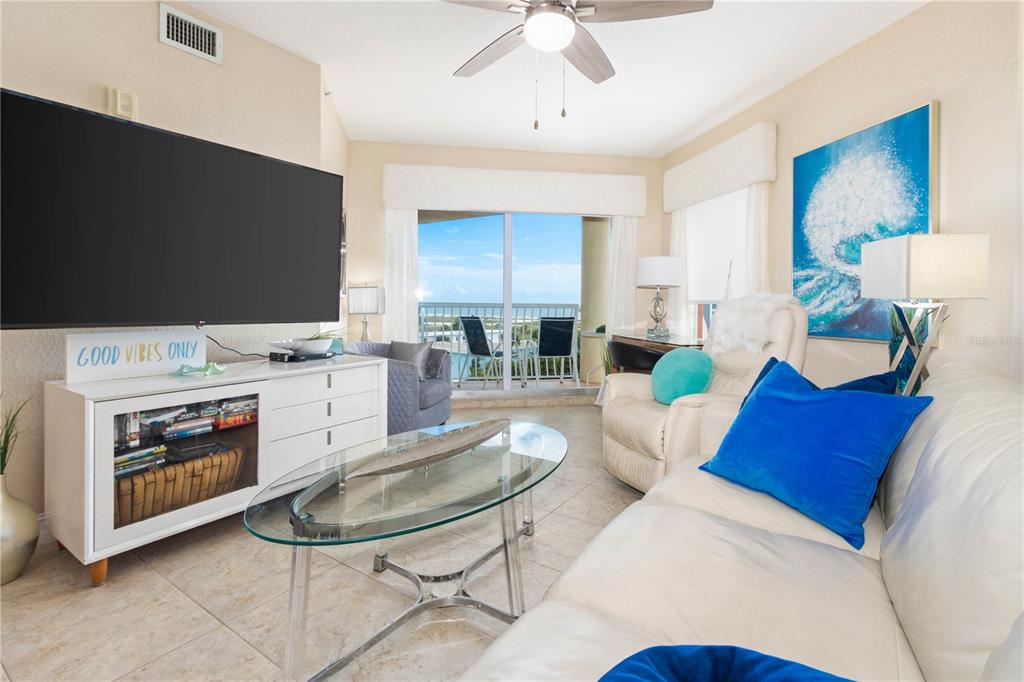 An aerial view shows multiple beachfront hotel buildings with swimming pools and a paved walkway — 11605 GULF BOULEVARD UNIT 503, TREASURE ISLAND, FL
