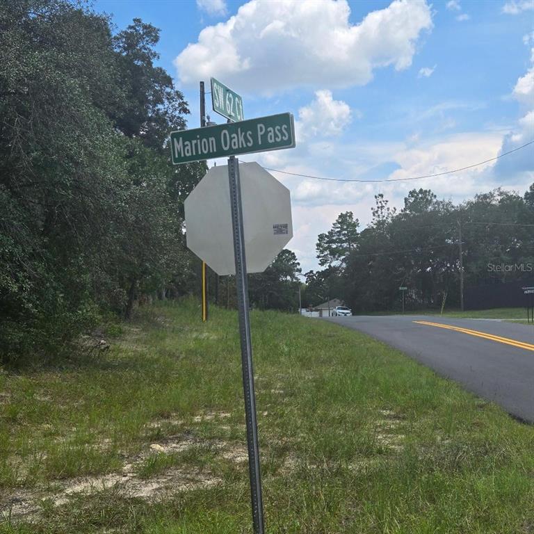 A street sign for Marion Oaks Pass stands above a blank stop sign near a road — TBD SW 62ND CT, OCALA, FL