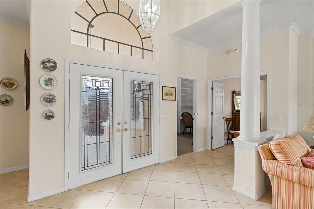 A bright entryway features double glass-paneled doors, a large arched window, and tiled flooring — 8405 MAYBELLE DRIVE, WEEKI WACHEE, FL
