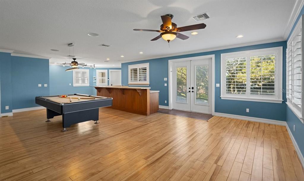 A spacious game room features blue walls, wood flooring, a pool table, and a bar — 2 MAR AZUL N, PONCE INLET, FL