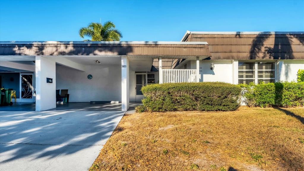 A single-story house with a carport, a large front lawn, and a palm tree — 3823 GLEN OAKS DRIVE E UNIT 83, SARASOTA, FL
