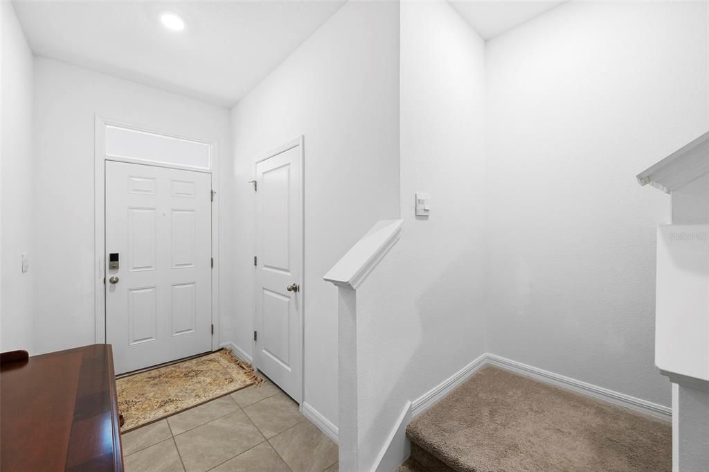 An entryway features a white front door, tiled floor, carpeted stairs, and a closet door — 369 MANGROVE SHADE CIRCLE, APOLLO BEACH, FL