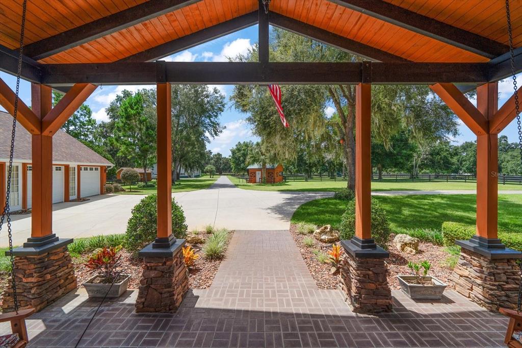 A view from a covered porch looking out onto a paved driveway and grassy yard — 7650 N WHIPPOORWILL TERRACE, HERNANDO, FL
