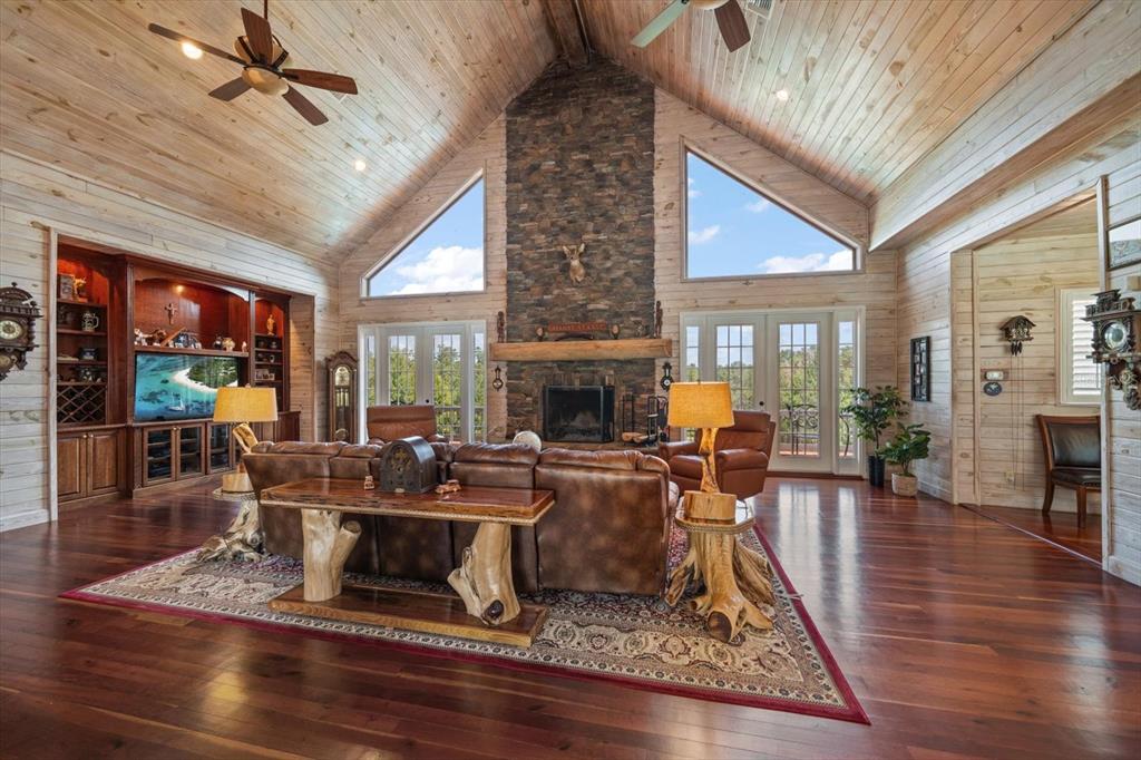 A living room features a stone fireplace, vaulted wood ceilings, and a leather sectional sofa — 7650 N WHIPPOORWILL TERRACE, HERNANDO, FL