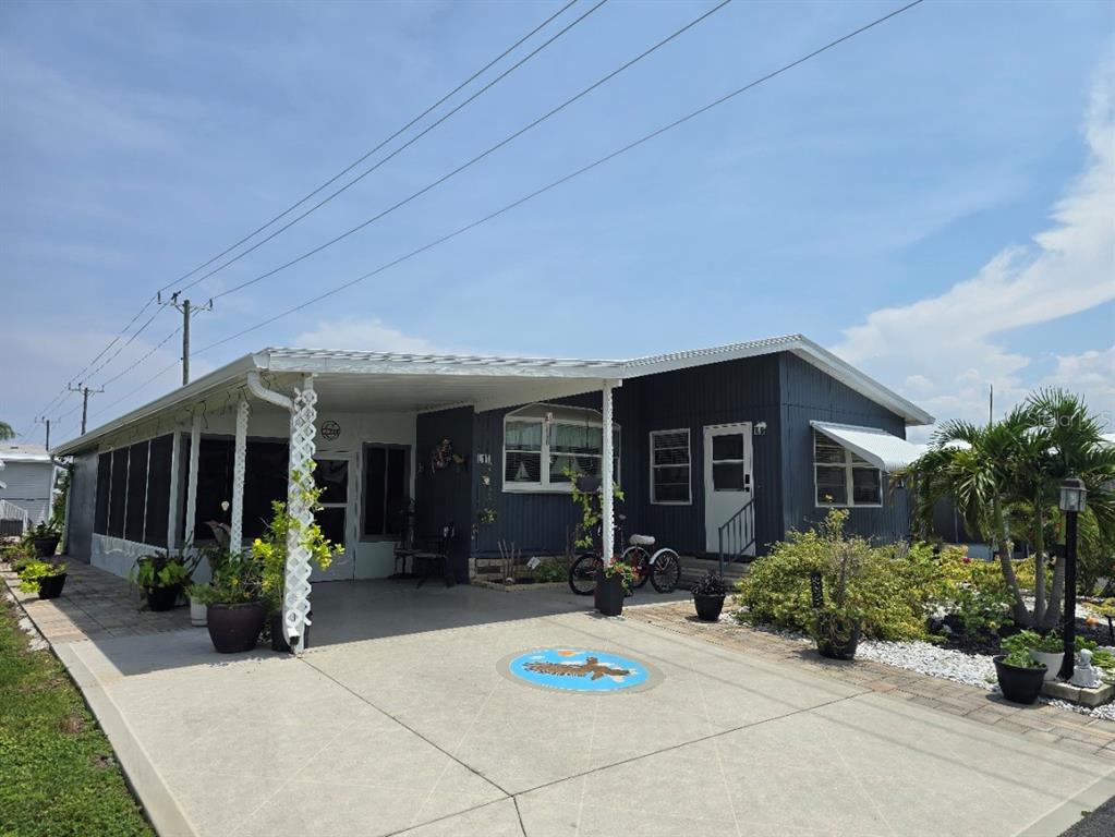 A single-story house at night with purple exterior accent lighting and a paved driveway — 5316 53RD AVENUE E UNIT L11, BRADENTON, FL