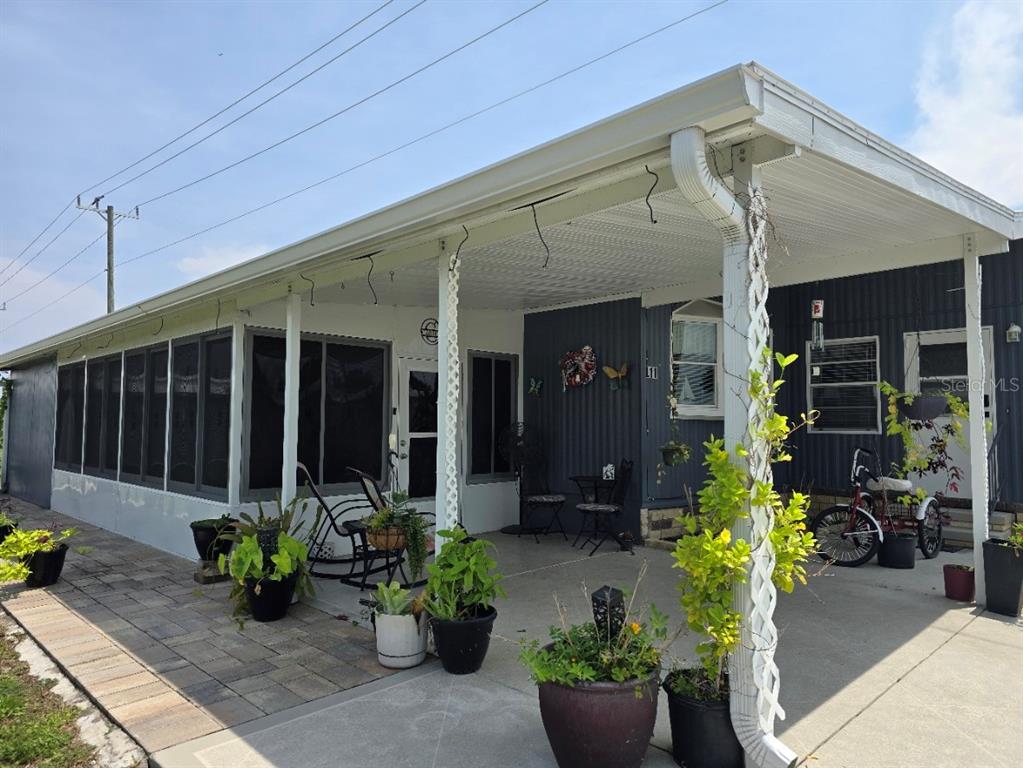 A single-story mobile home at night with purple roofline lighting and landscaped front yard — 5316 53RD AVENUE E UNIT L11, BRADENTON, FL