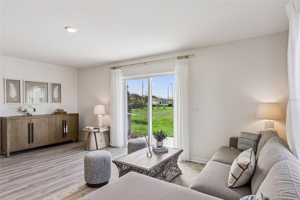 A living room features a gray sectional sofa, wood sideboard, coffee table, and sliding glass doors — 4710 TONY STREET, LAKE WALES, FL