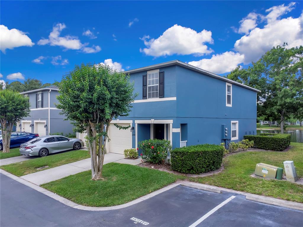 A two-story blue house with a garage and a small front yard under a cloudy sky — 12928 LEXINGTON SUMMIT STREET, ORLANDO, FL