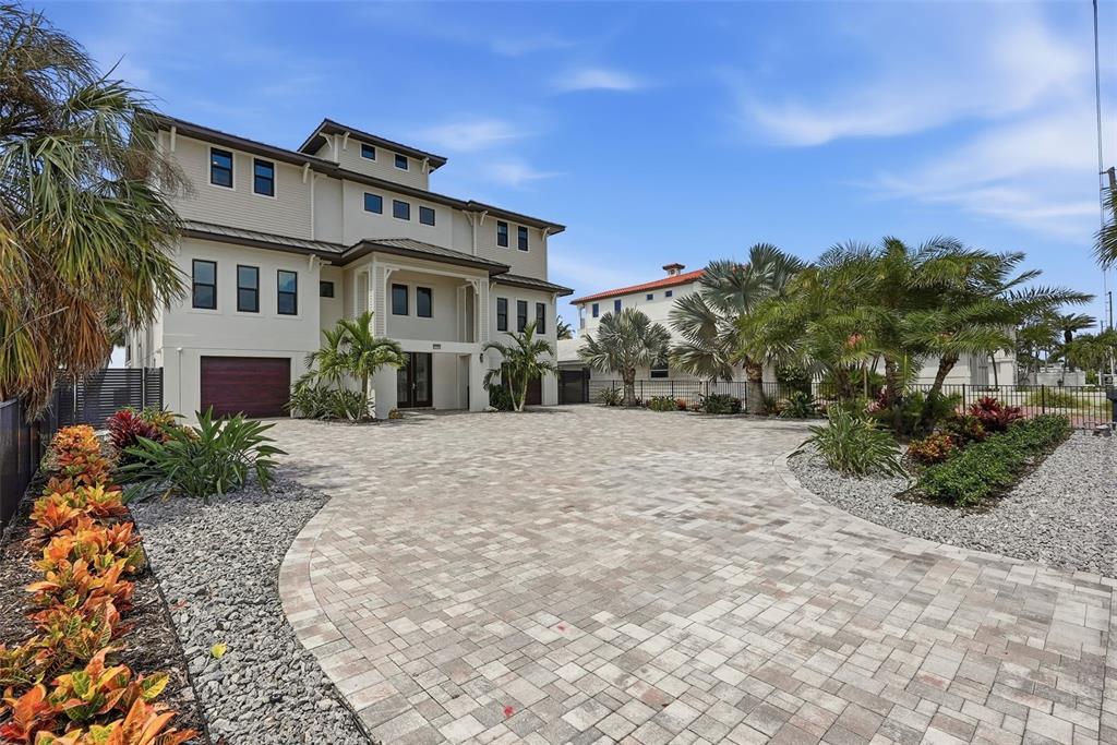 A large three-story house with a paved driveway and tropical landscaping — 15908 GULF BOULEVARD, REDINGTON BEACH, FL
