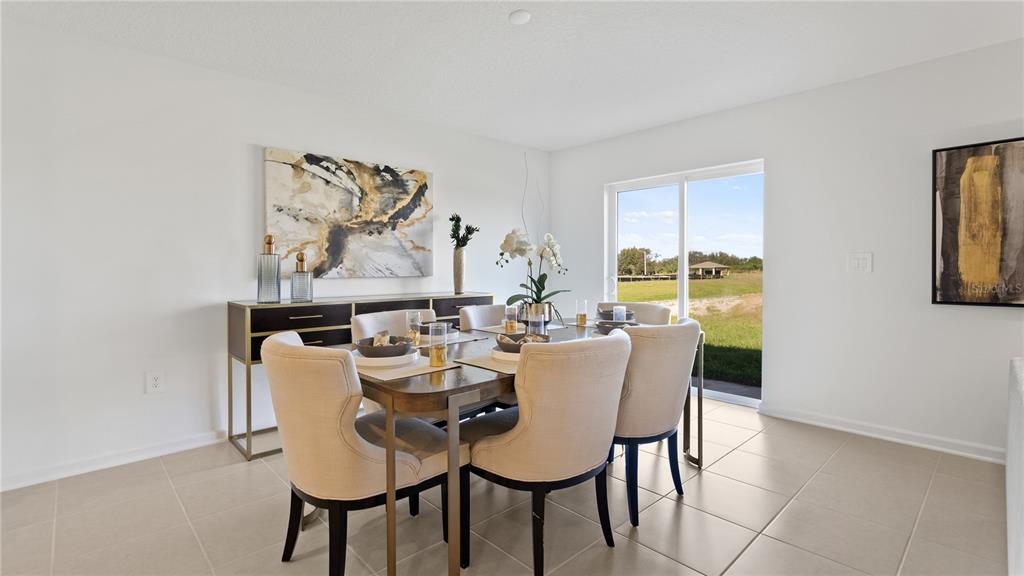 A dining room features a wooden table, upholstered chairs, a sideboard, and a sliding glass door — 1963 PINE MEADOWS GOLFCOURSE ROAD, EUSTIS, FL