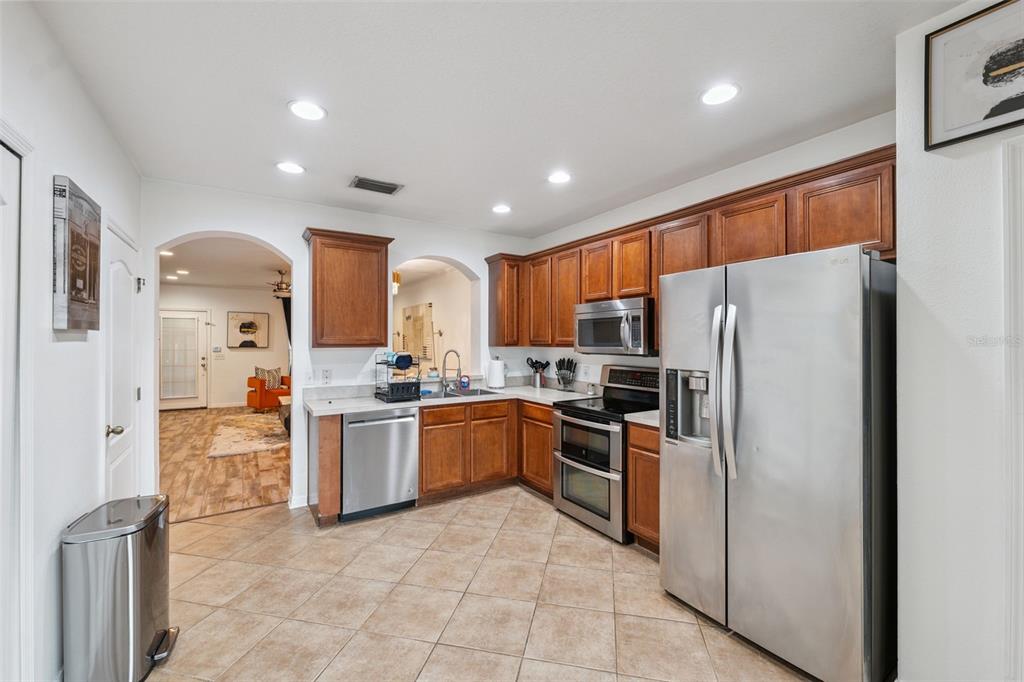A kitchen with wood cabinets, stainless steel appliances, and tile flooring — 12224 FOXMOOR PEAK DRIVE, RIVERVIEW, FL