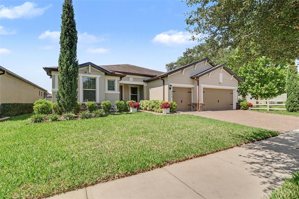 A single-story suburban house with a two-car garage and a manicured front lawn — 2898 MATERA DRIVE, ST CLOUD, FL