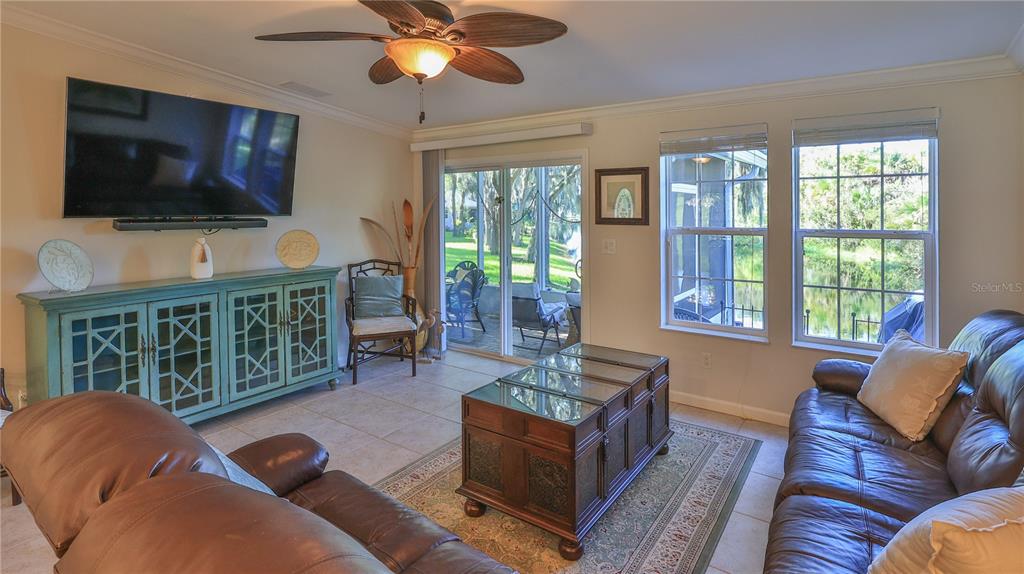 A living room features a brown leather sofa, a wooden coffee table, and a teal cabinet — 237 NAVAJO DRIVE, OAK HILL, FL