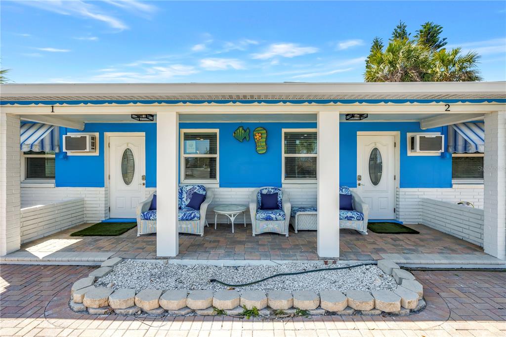 A blue and white exterior features two front doors with matching porches and patio furniture — 6892 GULF WINDS DRIVE UNIT 2, ST PETE BEACH, FL