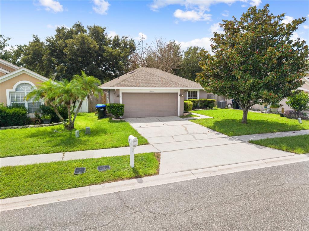 A single-story house with a two-car garage, a concrete driveway, and a front lawn — 10806 BROWN TROUT CIRCLE, ORLANDO, FL