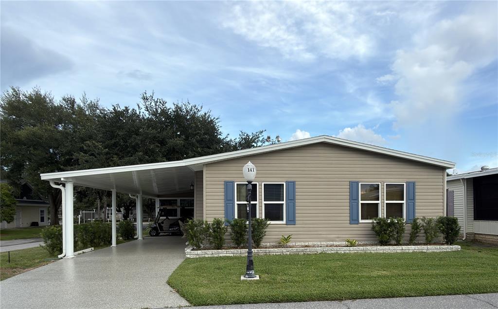 A dining area with a tiled table and hutch opens into a living room with blue walls — 141 VICTORIA DRIVE, HAINES CITY, FL